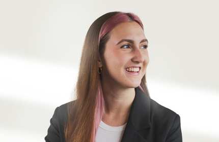 A portrait photo of a person against a plain white wall.