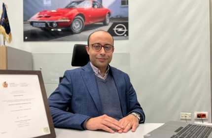 Mina Barsoum sits at a work desk which he has placed both hands on