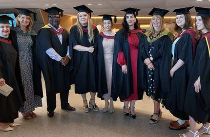Cardiff Met students in graduation gowns and caps standing in a line
