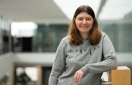 Sarah-May McVey stands leaning on a staircase handrail