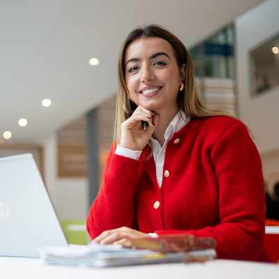 A person with dark hair sits in a chair, looking at a large computer monitor displaying various graphs and data in a financial analysis program.