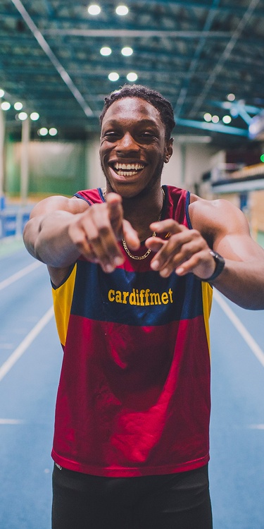 Cardiff Met athlete smiling and pointing at the camera in the winning mood.