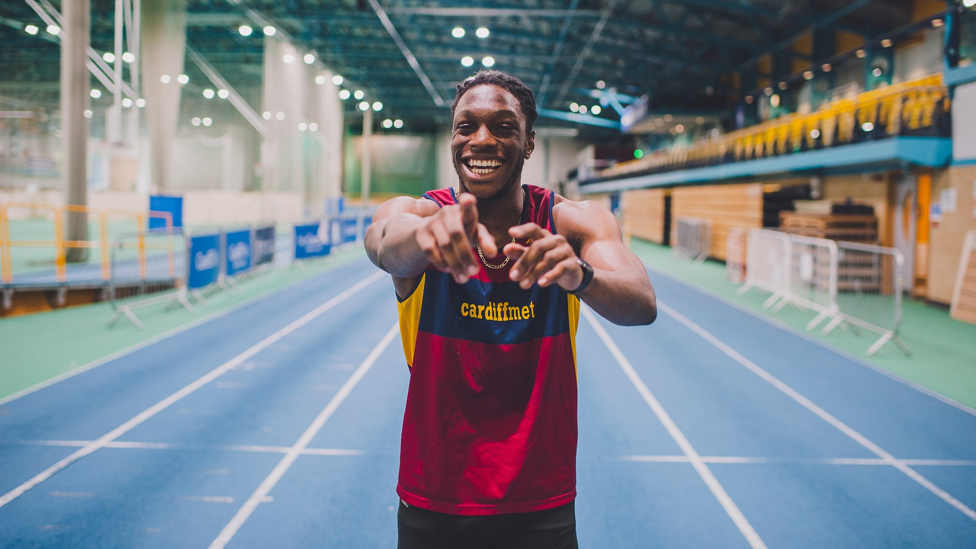 Cardiff Met athlete smiling and pointing at the camera in the winning mood.