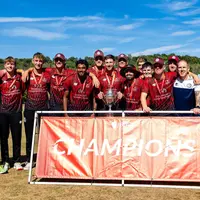 Several men are gathered in front of a banner saying Champions, displaying a sense of camaraderie and engagement.