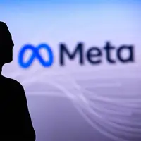 The Meta logo on a large screen in the background, with a blacked out figure on the side representing Mark Zuckerburg