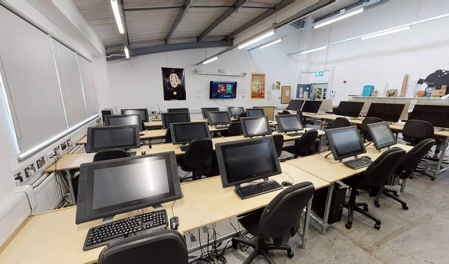 Room with rows of desks with computers and keyboards