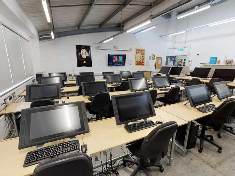 Room with rows of desks with computers and keyboards