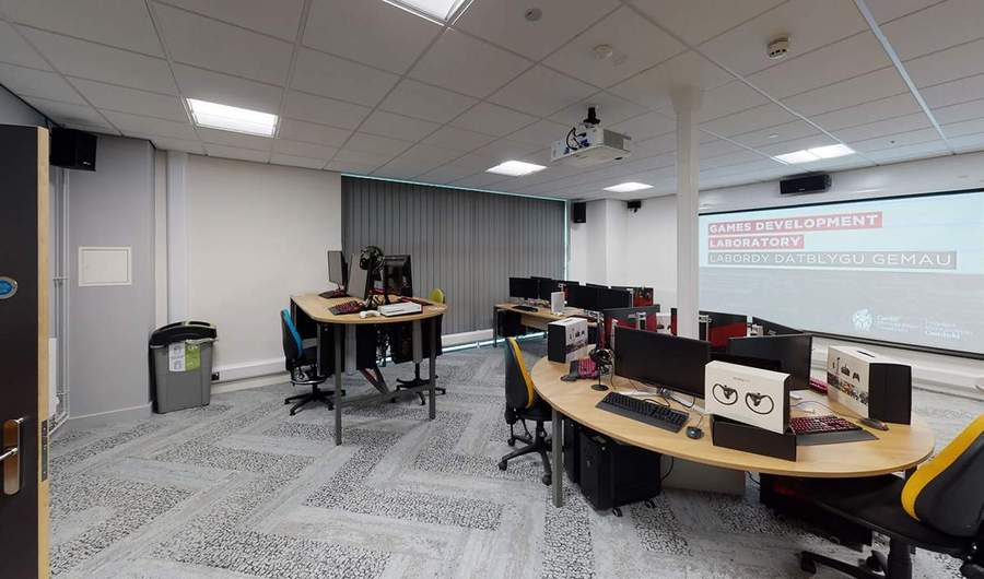 Computer desks in front of projector in office room.