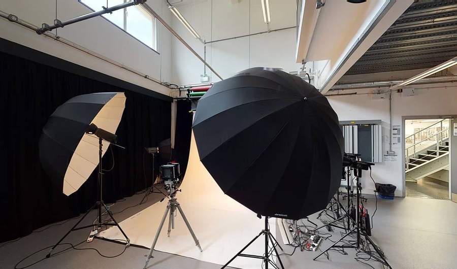 Photography shooting area with camera between two large lights pointed at a white background