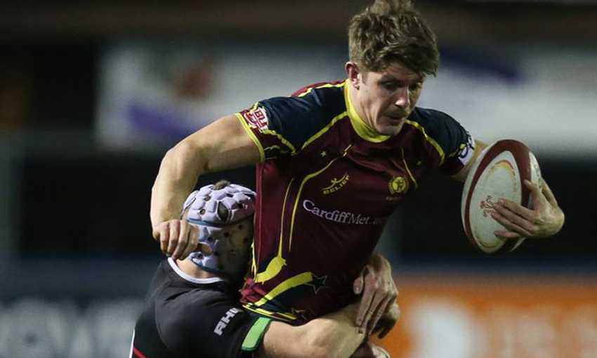 A Cardiff Metropolitan University rugby player is tackled from behind while during a game