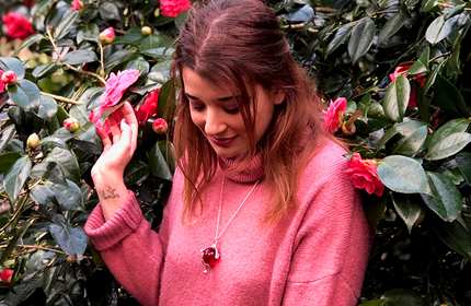 Athena Lambrou stands in front of a large rose bush