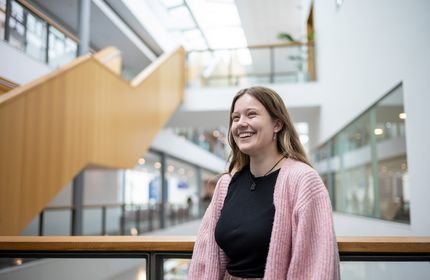 Heather Blackmore leans on the balcony of a mezzanine overlooking the Cardiff School of Management ground floor