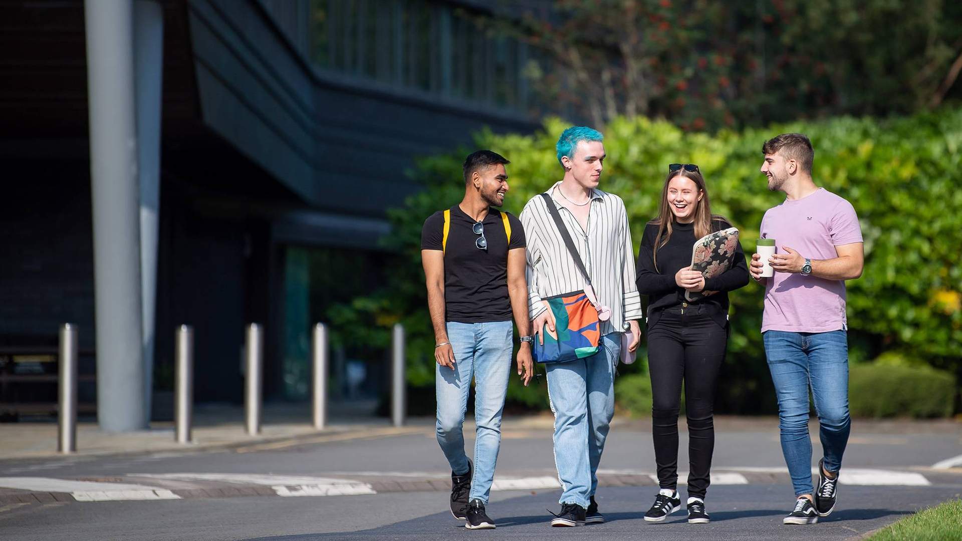 Group of 4 students walking through campus