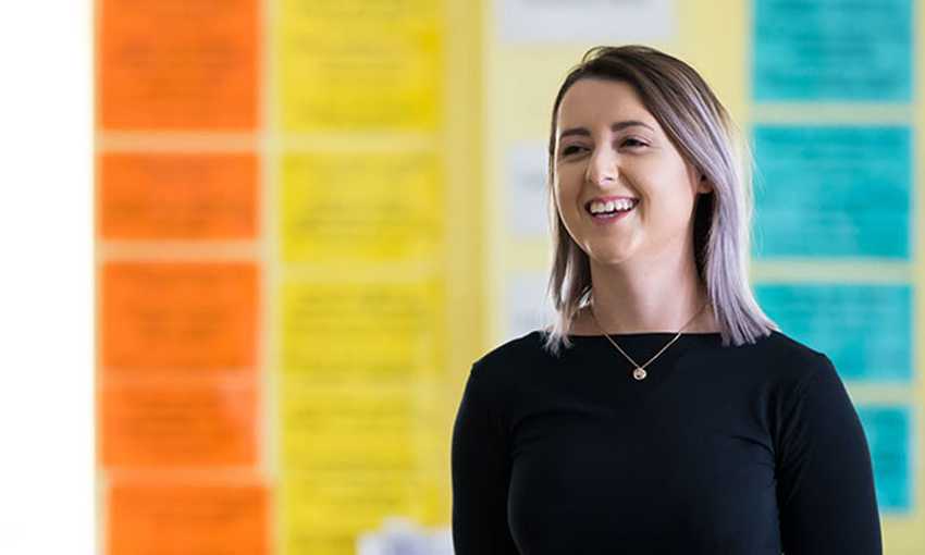 Headshot of smiling student in front of colourful background