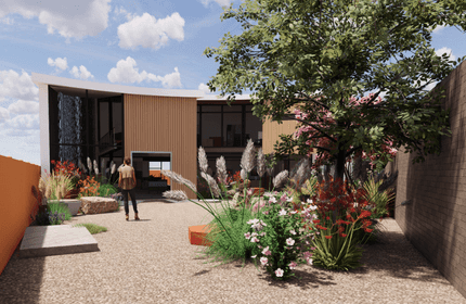 A modern house with a curved roof, large glass windows, and wood paneling, surrounded by a landscaped garden. A person walks along a gravel path, with colorful flowers and a tree in the foreground under a partly cloudy sky.