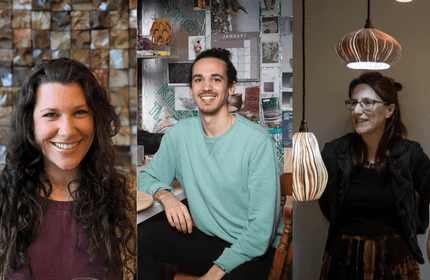 A trio of smiling individuals sits in front of a table, exuding joy and camaraderie.