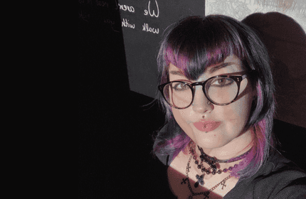 A student in a dark room, displaying creativity and passion to her craft